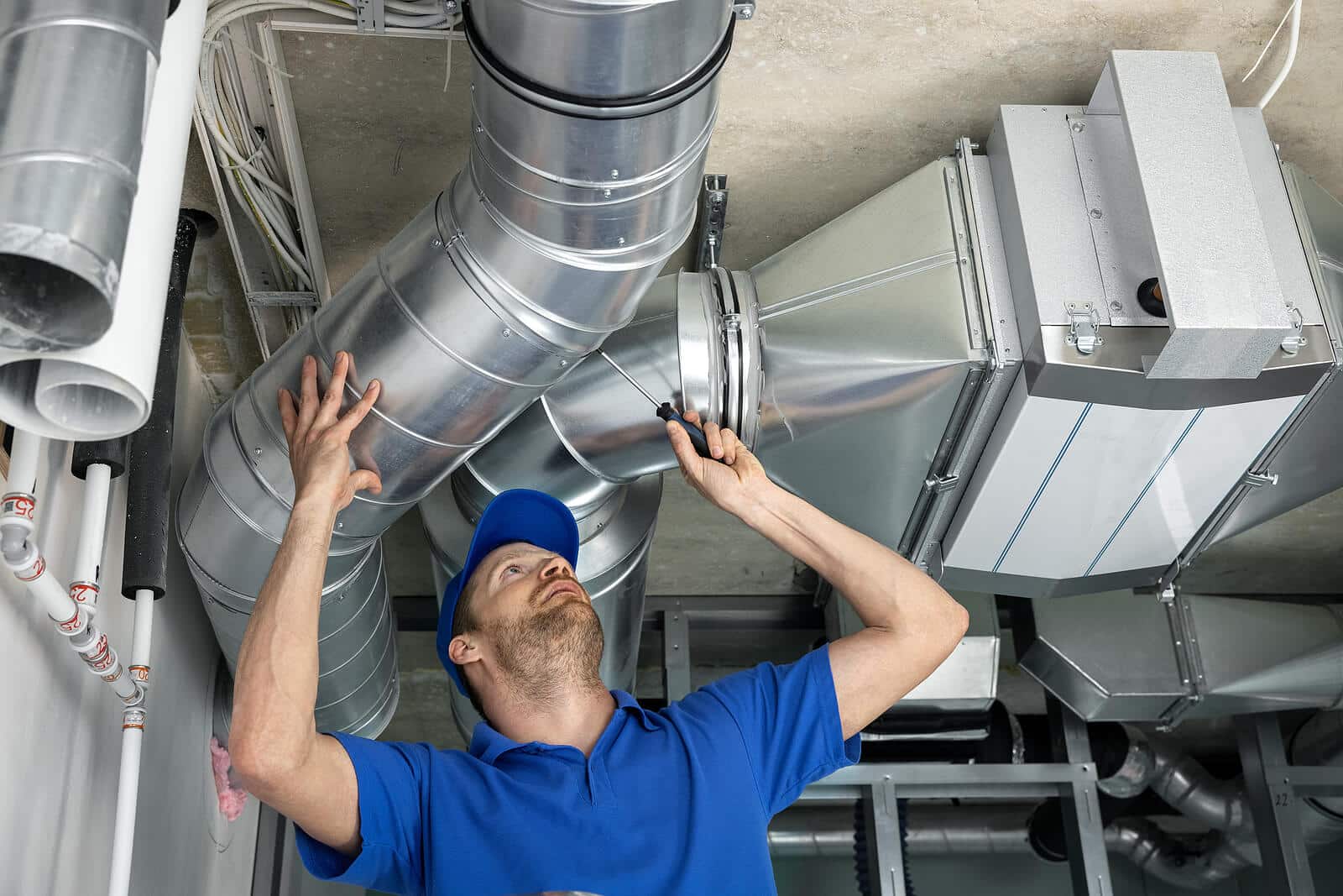 HVAC technician inspecting and repairing air ducts in Pomona