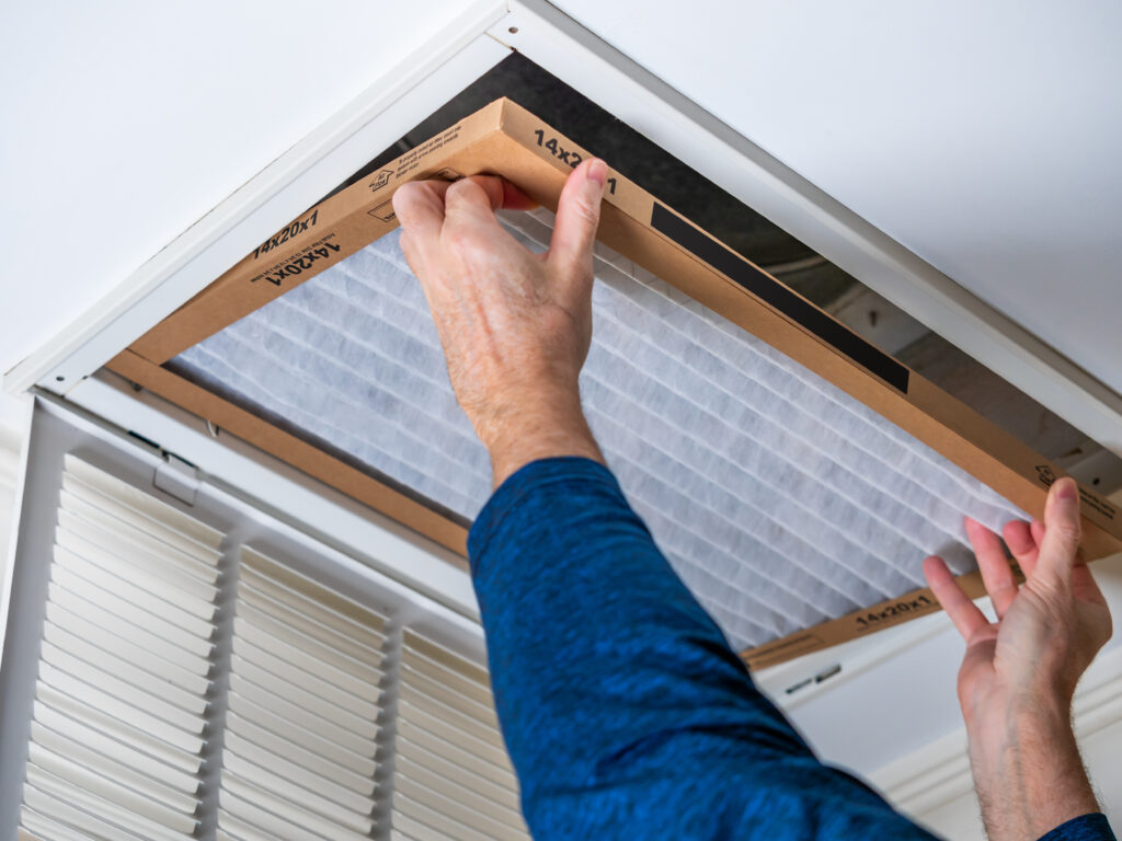 HVAC technician replacing a home air filter in Pomona