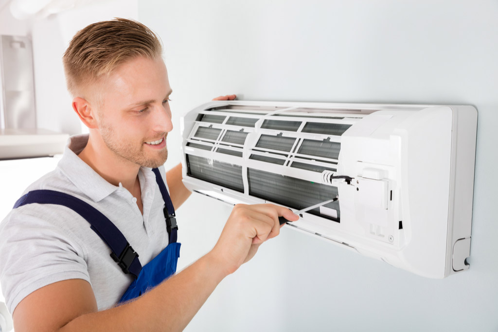 HVAC technician maintaining a ductless air conditioner in Pomona