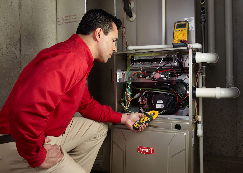 Heating technician diagnosing a furnace repair in Pomona