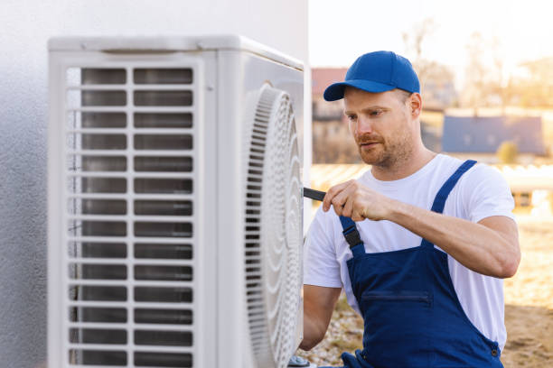HVAC technician servicing an outdoor air conditioner in Pomona